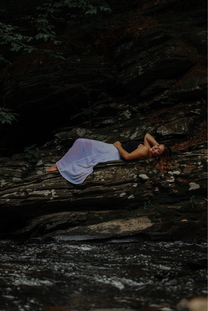 Portrait sitting on a log in the woods